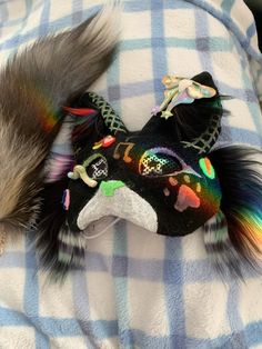 a skunko is laying on a blanket next to a stuffed animal that looks like a mask