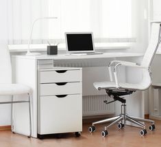 an office desk with a laptop computer on top of it next to a white chair