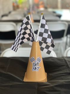 two flags sticking out of a cone sitting on top of a black tablecloth covered table