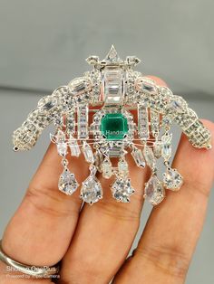 Edwardian era Inspired Antique 925 sterling silver American diamond bezel set Queen Elizabeth II Emerald Sarpech brooch  wedding/ love gift Metal: Sterling Silver Metal Purity: 925 Metal Wt:.12.98 Grams Diamond Type: American Diamond  Diamond Color: white Diamond Clarity: I1-I2  Diamond Cut: Good Diamond Shape: Round  Diamond Wt: 8.89 Ctw Gemstone: Emerald Gemstone weight: 1.00 ctw Length:2.5 inches Width:3.00 inches Product Color: Oxidized Black and Gold Rhodium Plated on Sterling Silver Brooch Wedding, American Diamond, Emerald Gemstone, Best Diamond, Bezel Diamond, Diamond Color, Diamond Shape, Queen Elizabeth Ii, Elizabeth Ii