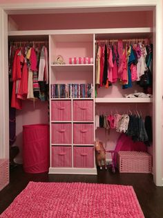 a pink closet with clothes and toys in it