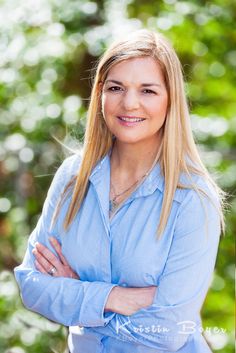 a woman with blonde hair and blue shirt posing for a photo