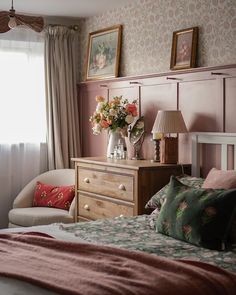 a bed room with a neatly made bed next to a window and a chair in front of it