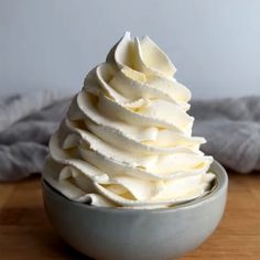 a bowl filled with whipped cream on top of a wooden table