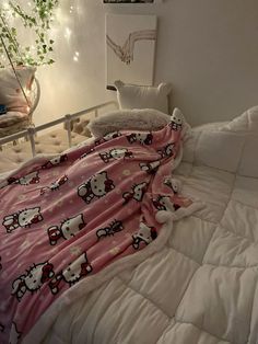 an unmade bed with hello kitty blankets on it