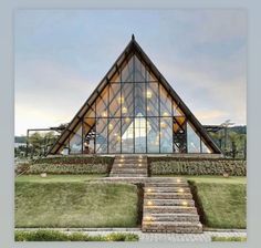 a large glass building with stairs leading up to it