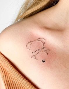 a woman's shoulder with a dog paw tattoo on the left side of her chest