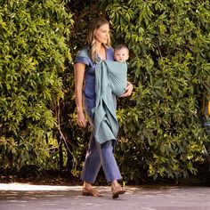 a woman walking with a baby in her sling