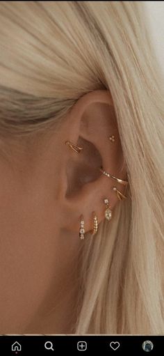 a woman with blonde hair wearing three different ear piercings on her left side and one behind the ear