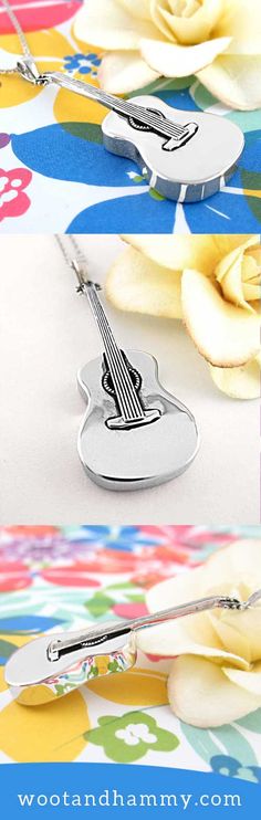 a guitar shaped keychain sitting on top of a flowery tablecloth with flowers in the background