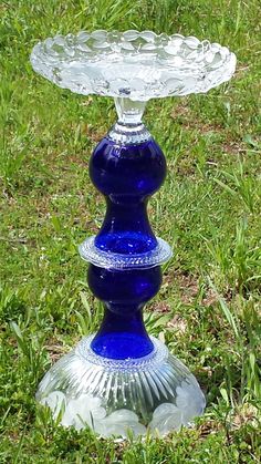 a blue glass pedestal sitting in the grass