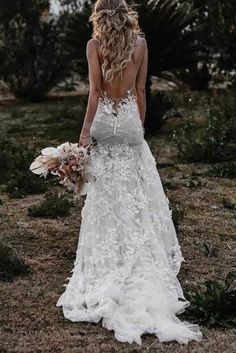 a woman in a white wedding dress is standing on the ground with her back to the camera