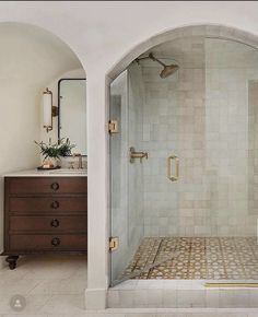 a bathroom with a walk in shower sitting next to a sink and a mirror on the wall