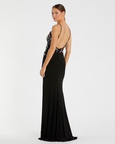 a woman in a long black dress with floral appliques on it's back