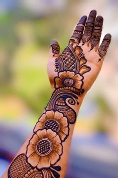 a woman's hand with henna tattoos on it