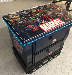 an arcade machine with the avengers logo on it's front and side panels lit up