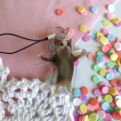 a keychain with a small mouse on it next to some confetti