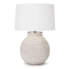 a white table lamp with a white shade on it