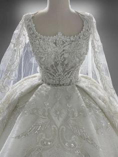 a white wedding dress with long sleeves and beading