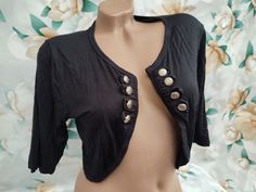 90s Vintage viscose women's black cropped double-breasted bolero short sleeve. Size M-L. Bolero is in excellent vintage condition. Bust approx 94cm (37in), bolero length 41cm (16in). Trendy Fitted Summer Shrug, Fitted Trendy Shrug For Summer, Trendy Fitted Shrug For Summer, Fitted Cropped Tops With Buttons, Fitted Cropped Black Shrug, Black Fitted Cropped Shrug, Black Cropped Jacket With Button Closure, Cropped Stretch Shrug For Spring, Spring Cropped Stretch Shrug