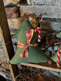 two green christmas trees sitting on top of a wooden shelf