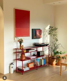 a living room filled with furniture and a wooden table next to a plant on top of a book shelf