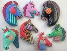 several colorfully painted horse heads sitting on top of a table