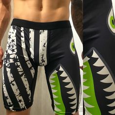 the man is showing off his muscular body in swim trunks with shark designs on it