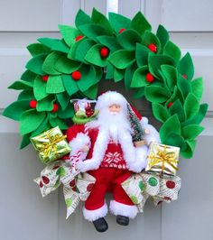 a christmas wreath with a santa clause holding presents