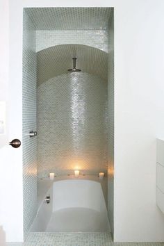 an image of a bathroom with candles on the bathtub and in the shower area