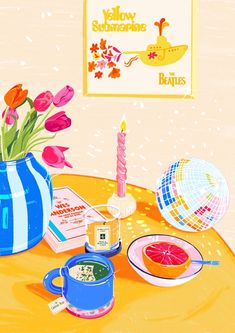 there is a blue vase with flowers in it and other things on the table next to it