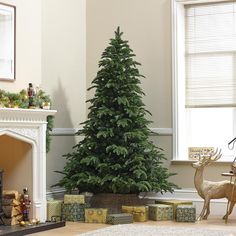 a christmas tree in the corner of a living room with presents on the floor next to it