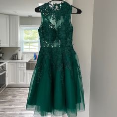 a green dress hanging on a rack in a kitchen