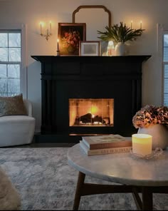 a living room with a fire place and two candles on the coffee table in front of it