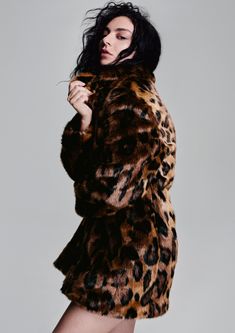 a woman in a leopard print coat posing for the camera