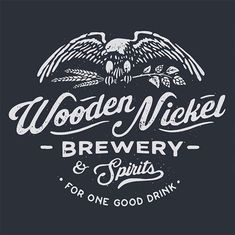 the logo for wooden nickel brewery and spirits, with an eagle on it's back