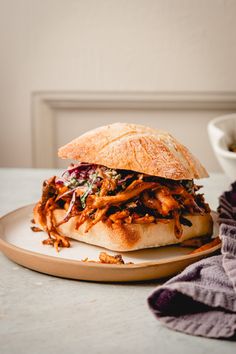 a pulled pork sandwich with cole slaw on a plate