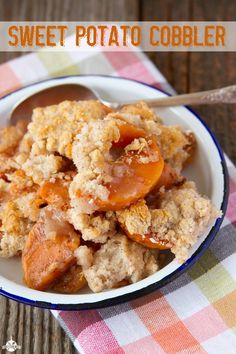 sweet potato cobbler in a white bowl on a checkered tablecloth with spoon