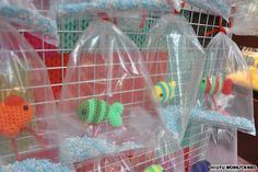 plastic bags filled with toys in the shape of fish and sea creatures on display at a store