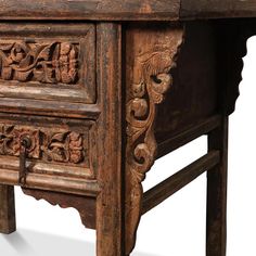 an old wooden table with carvings on the top and bottom drawer, isolated against a white background