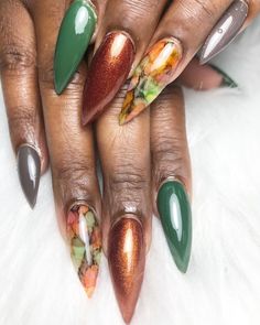 This striking design features a combination of earthy tones and a vibrant, multi-colored marble art on almond-shaped nails. The use of green, brown, and a shimmering copper polish creates a rich and luxurious look, perfect for the fall season. The marble effect on a couple of nails adds a unique and artistic flair to the overall design.   Photo credit by: @rvanails Copper Red Nails, Tier 2 Nail Art, Vibrant Fall Nails, Olive And Brown Nails, Fall Leaf Nails Autumn Leaves, Green And Copper Nails, Green Orange Nails, Copper Nails Acrylic, Fall Nails Ideas Autumn Square