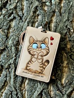 a keychain with an image of a cat on it hanging from a tree