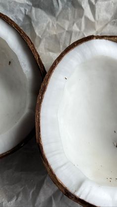 two whole coconuts sitting on top of a piece of paper