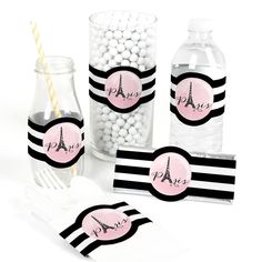 pink and black paris themed party supplies with striped napkins, candy bar wrappers, and water bottle