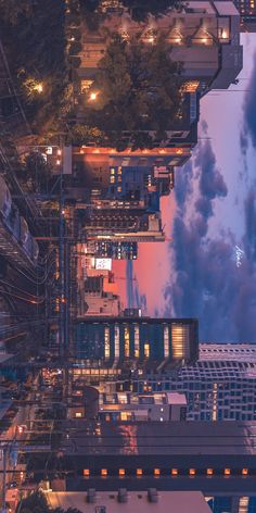 an aerial view of the city at night with clouds in the sky and buildings lit up