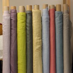 a row of different colored linens hanging on a wall