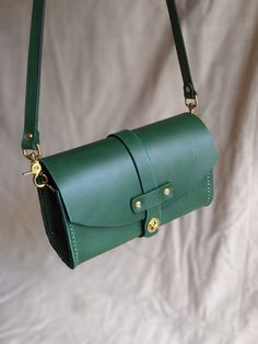 This handmade purse is a simple elegant design. Made of top grain cow hide English bridle leather. green.  It is stitched and riveted for strength with solid brass rivets and hardware. With proper care it can last a lifetime. Green Leather Bag With Snap Closure, Green Leather Shoulder Bag With Snap Closure, Green Leather Bags With Brass Hardware, English Bridle, Handmade Purse, Handmade Purses, Cow Hide, Simple Elegant, Leather Purse