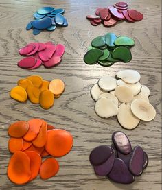 there are many different shapes and colors of buttons on the wooden table, including one that has been cut into smaller pieces