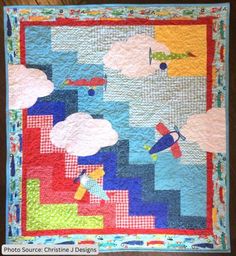 a quilted wall hanging with an airplane and clouds on it