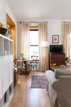 a living room filled with furniture and a flat screen tv on top of a wooden table